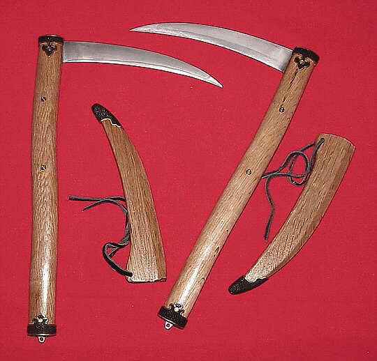 A pair of kamas with wooden handles and curved blades
